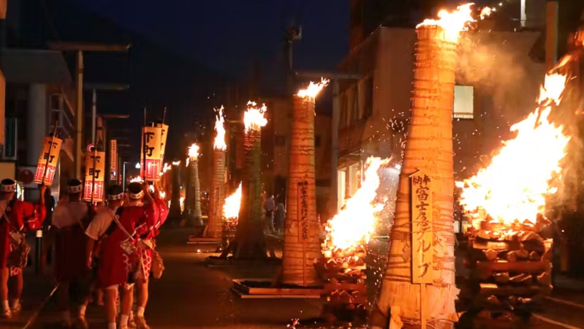 Night festival in rural Japan with fire torches and masked dancers